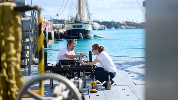Two people work on a boat in Bermuda